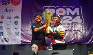 Penyerahan piala juara umum oleh ketua panitia POM UKSW 2024 Mathden Letare Manurung kepada perwakilan mahasiswa FTI dalam acara POM 2024 di Lapangan Sepak Bola UKSW, Sabtu (06-07-2024) malam (2)