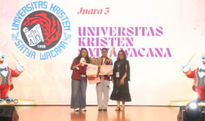 Dirigen dan Ketua Voice of SWCU saat menerima piala Juara 3 Pesta Paduan Suara Gerejawi Mahasiswa Nasional (PESPARAMA) 2026.